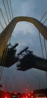 Photo of a bridge that is still under construction, where the structure of the bridge uses a balanced cantilever concrete box girder