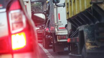 cerca arriba foto de un espalda lámpara de coche ese atascado en un tráfico mermelada en el carretera, con un bokeh antecedentes.