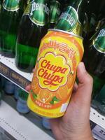 Bangkok, Thailand on July 22, 2023. A hand is holding a can of Chupa Chups Sparkling Orange Drink. photo