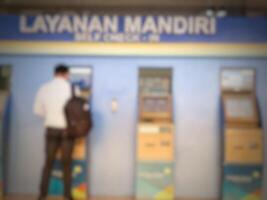 Jakarta, Indonesia on July 7 2022. Defocused photo or blurred photo of an airplane passenger who is self-checking in at the machine available at Halim Perdanakusuma Airport.