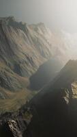 un' mozzafiato aereo Visualizza di maestoso illuminata dal sole montagna picchi video