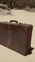 un' pezzo di bagaglio seduta su superiore di un' sabbioso spiaggia video