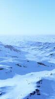 A majestic snow-covered mountain range under a clear blue sky video