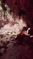 A person resting on a rocky surface inside a cave video