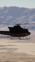 A helicopter flying over a snow covered mountain range video