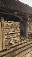 een rustiek houten gebouw omringd door gestapeld logboeken video