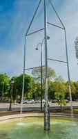 Modern water fountain installation on a sunny spring day in Paris, France, against a clear blue sky, captured on April 14th, 2024 ideal for travel and design themes photo