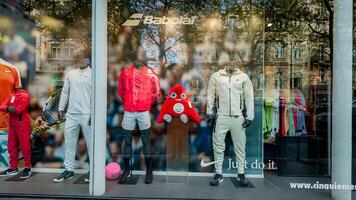Vibrant display of sportswear with plush toy in a Parisian store window, showcasing fashion and leisure, April 14th, 2024, Paris, France photo