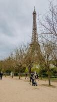 Springtime in Paris, visitors enjoying a stroll near the Eiffel Tower on a cloudy day, captured in Paris, France, on April 14th, 2024, ideal for travel themes photo