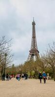 Tourists enjoying a spring day near the Eiffel Tower in Paris, France, captured on April 14th, 2024, ideal for travel and European landmarks themes photo