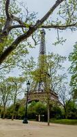 Springtime view of the Eiffel Tower framed by budding trees in Paris, France, captured on April 14th, 2024, suitable for travel and European landmarks themes photo