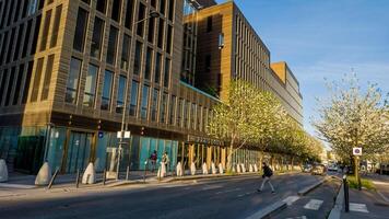 Early spring in Paris, France, showing pedestrians and modern architecture with blossoming trees on April 14th, 2024, ideal for travel and urban life content photo