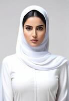 Portrait of a Middle Eastern woman in a white hijab against a neutral background, suitable for topics on cultural diversity and Islamic holidays such as Ramadan photo