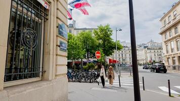 Urban Parisian street scene with pedestrians, French flags, and architecture, encapsulating daily life in Paris, France, on April 14th, 2024, ideal for travel and culture themes photo