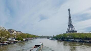 Scenic view of the Eiffel Tower from the Seine River with a moving barge, symbolizing Parisian culture and tourism, captured in Paris, France, on April 14th, 2024 photo