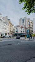 típico parisino calle escena en París, Francia, con bullicioso tráfico y clásico arquitectura en abril 14, 2024, ideal para viaje y urbano estilo de vida temas foto