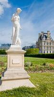 Classic white marble statue in a blooming Parisian garden, symbolizing European art and history, captured in Paris, France, on April 14th, 2024 photo