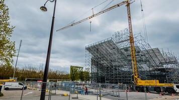 Construction site with scaffolding and crane in Paris, France, on April 14th, 2024, symbolizing urban development and labor industry progress photo