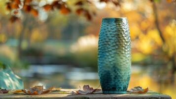 A tall narrow vase in shades of blue and green showcasing the natural texture of the ceramic. photo