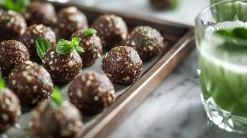 A tray of raw vegan energy bites perfect for pairing with a refreshing green juice cocktail photo