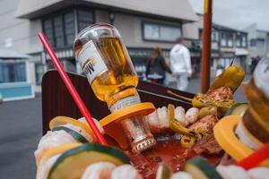 Colorful Food Platter with Skewers, Red Sauce, and Whiskey, Outdoors photo