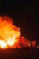 Intense bonfire illuminates desert festival night. photo