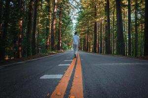 tranquilo californiano escena persona caminando en boscoso la carretera foto