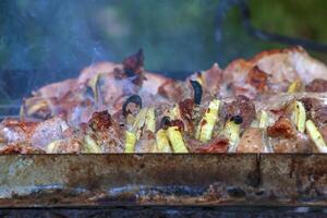 Cocinando kebabs en un parrilla con fumar. Fresco marrón barbacoa carne cocido en un al aire libre parrilla foto