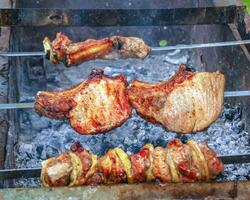 Cocinando kebabs en un parrilla con fumar. Fresco marrón barbacoa carne cocido en un al aire libre parrilla foto