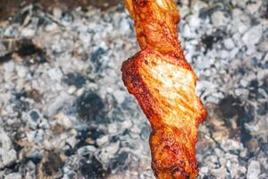 Cocinando kebabs en un parrilla con fumar. Fresco marrón barbacoa carne cocido en un al aire libre parrilla foto