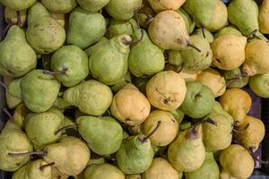 Pears Conference. Pear fruits pile on the farmer market counter. Fresh green pear texture. Top view texture of dirty pears. Market sale. Food market stand. Minimalist, simple concept. photo