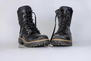 antiguo usado roto negro cuero Ejército cordón botas. de moda otoño botas. elegante De las mujeres de los hombres unisexo grunge botas con cordón. alto militar Zapatos aislado en blanco antecedentes. plano poner. Copiar espacio foto