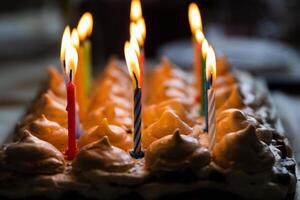 Closeup 15 colorful lit candles at the birthday party at home. Large homemade chocolate cake, decorated with meringues and whipped cream. Celebration concept. Selective focus. photo