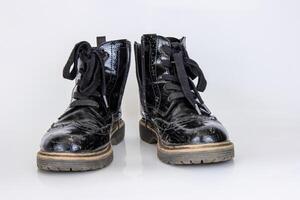 antiguo usado roto negro cuero Ejército cordón botas. de moda otoño botas. elegante De las mujeres de los hombres unisexo grunge botas con cordón. alto militar Zapatos aislado en blanco antecedentes. plano poner. Copiar espacio foto