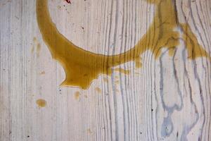 Coffee stains on white wooden table. Wood texture background. Big dark brown dramatic Splatter, fleck, splash, spot, drops of black coffee. Pattern, wallpaper. Top view. Closeup. Copy space. photo