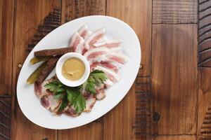 smoked and salted lard on a white oval plate. photo