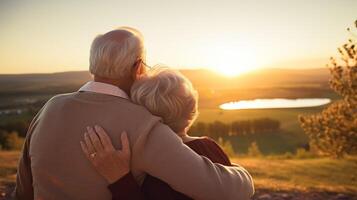 A couple of seniors sharing a loving embrace as they watch the sun set over the rolling hills of their favorite golf course photo