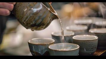 él cuidadosamente vierte caliente agua dentro el tazas cada movimiento deliberar y intencional foto