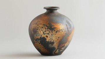 A small vase with a glossy black surface and areas of metallic gold and bronze representing the unique and complex glaze combinations possible through soda firing. photo