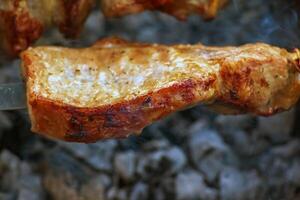 Cooking kebabs on a grill with smoke. Fresh brown BBQ meat cooked on an outdoor grill photo