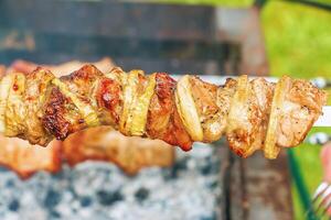 Cocinando kebabs en un parrilla con fumar. Fresco marrón barbacoa carne cocido en un al aire libre parrilla foto