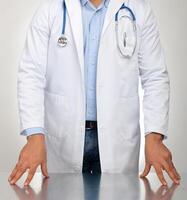 médico con manos descansando en el mesa para examen foto