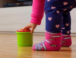 Toddler baby girl plays with colored cups photo