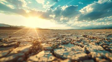 agrietado tierra en un estéril campo debajo un abrasador sol, sequía concepto foto