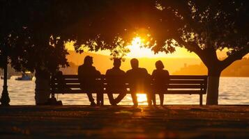 Silhouettes of people sitting on wooden benches enjoying the heat. photo