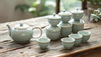 A small teapot sits next to a stack of delicate tea cups ready to be filled and shared with friends photo