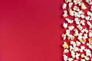 Popcorn pattern, border on red background. Top view, flat lay with copy space photo