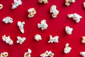 Popcorn pattern on red background. Top view, flat lay photo