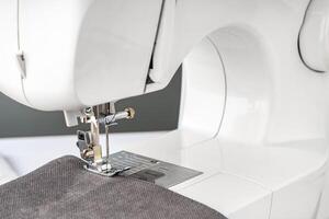 Modern sewing machine with gray fabric photo