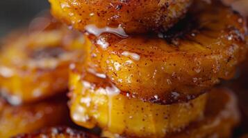 A stack of crispy fried plantains drizzled with a sweet coconut glaze and dusted with cinnamon photo